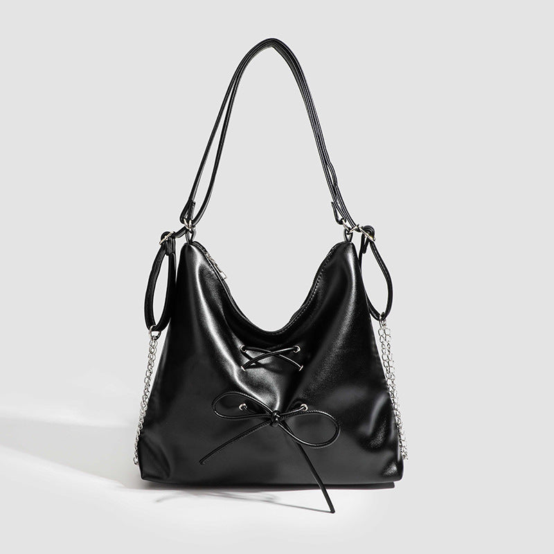 Glossy leather-look hobo shoulder bag with front bow lacing detail and silver-tone chain strap, detail view 7