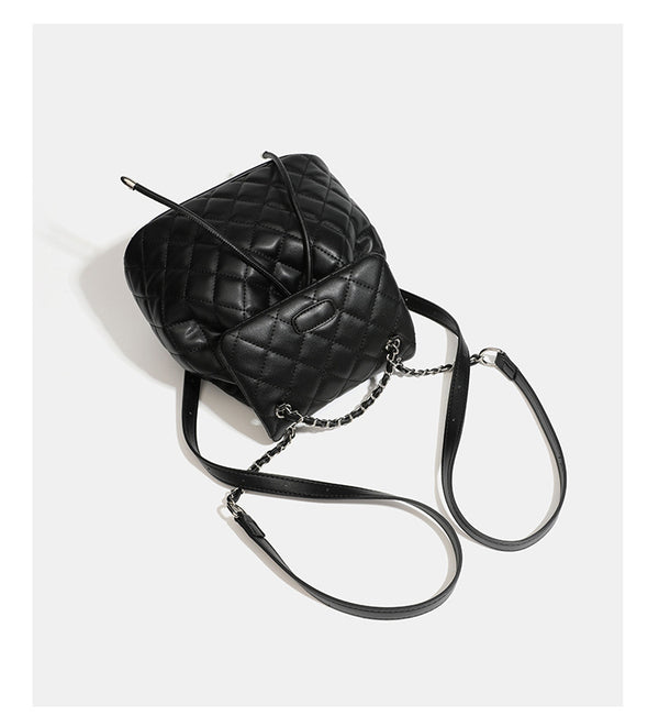 Black diamond-quilted backpack handbag with silver-tone chain flap accent and adjustable shoulder straps, detail view 15