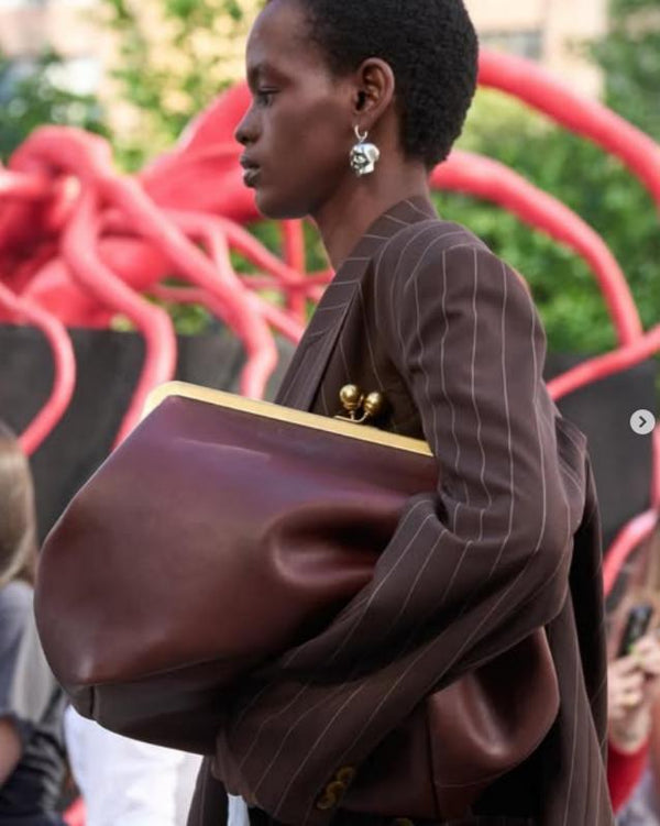 Oversized kiss-lock frame handbag with gold-tone metal clasp and smooth leather-look finish, detail view 20