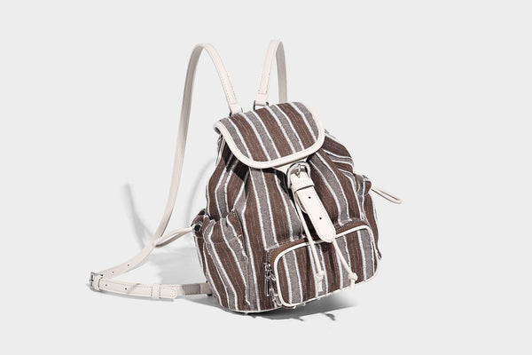 Weicher Rucksack aus gewebtem Material mit vertikalen Streifen, Überschlag, Kordelzug, vorderer Reißverschlusstasche, weißen Besätzen und Trägern in Lederoptik, Detailansicht