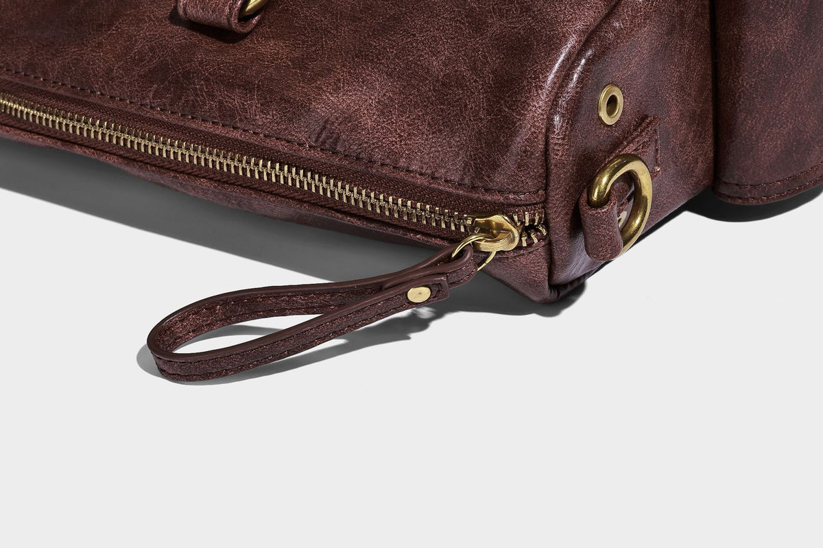 Distressed leather-look vintage satchel shoulder bag with multiple front zip pockets, dual top handles, and brass-tone