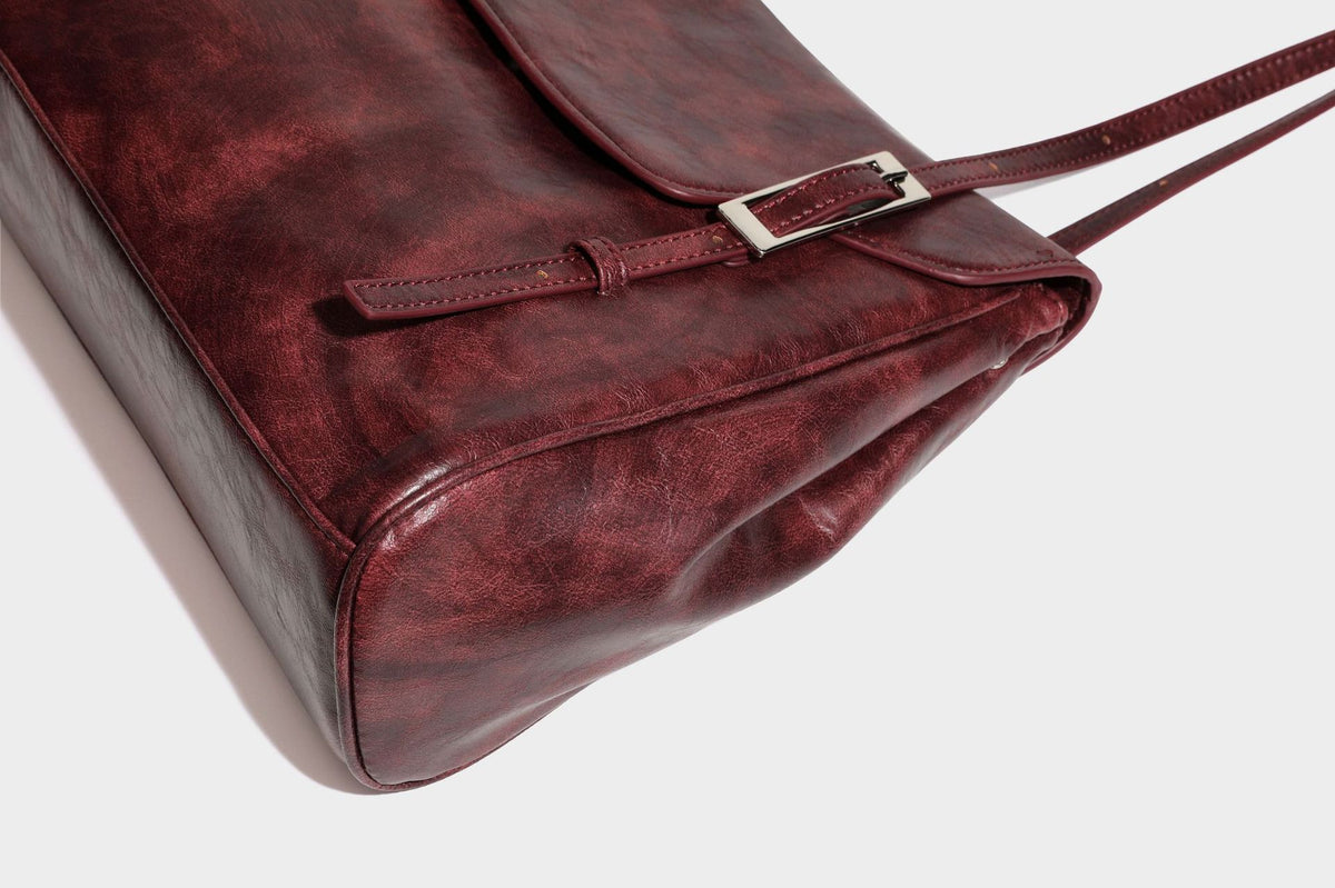Structured flap-top shoulder tote bag in distressed leather-look finish with silver-tone buckle hardware and double shoulder