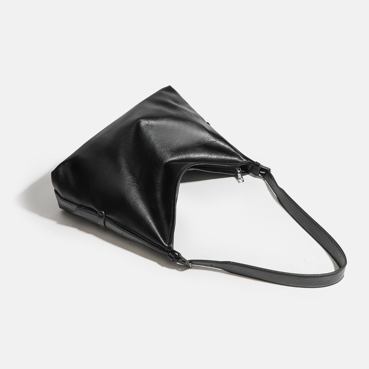 Große, lässig fallende schwarze Schultertasche in Lederoptik mit Reißverschluss, breitem, flachem Boden und langem verstellbarem Riemen, Detailansicht 4