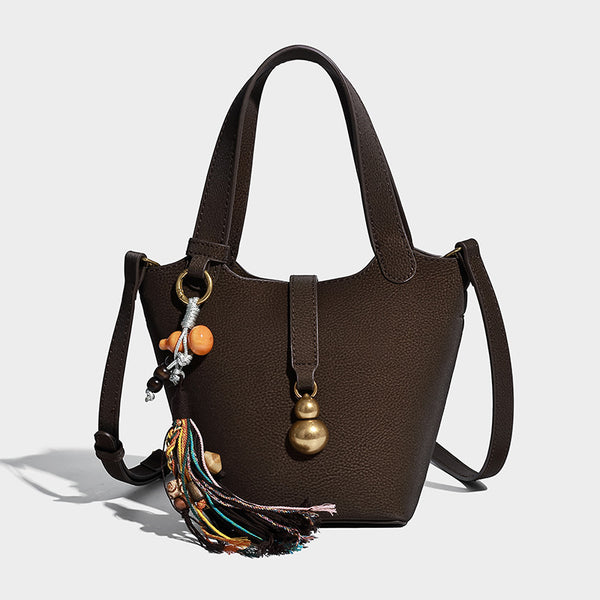 Kleine Beuteltasche mit genarbter, matter Oberfläche, antikgoldfarbenen Ringbeschlägen, Perlen- und Quastenanhänger, kurzen Henkeln und