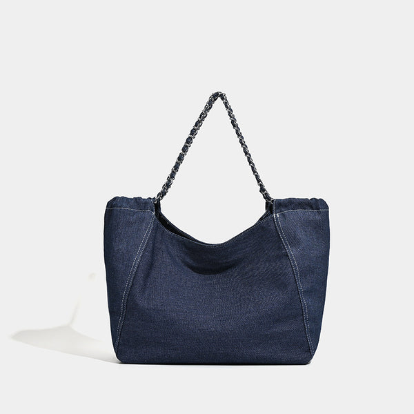 Large slouchy denim tote bag with silver-tone chain strap and contrast topstitching, front view