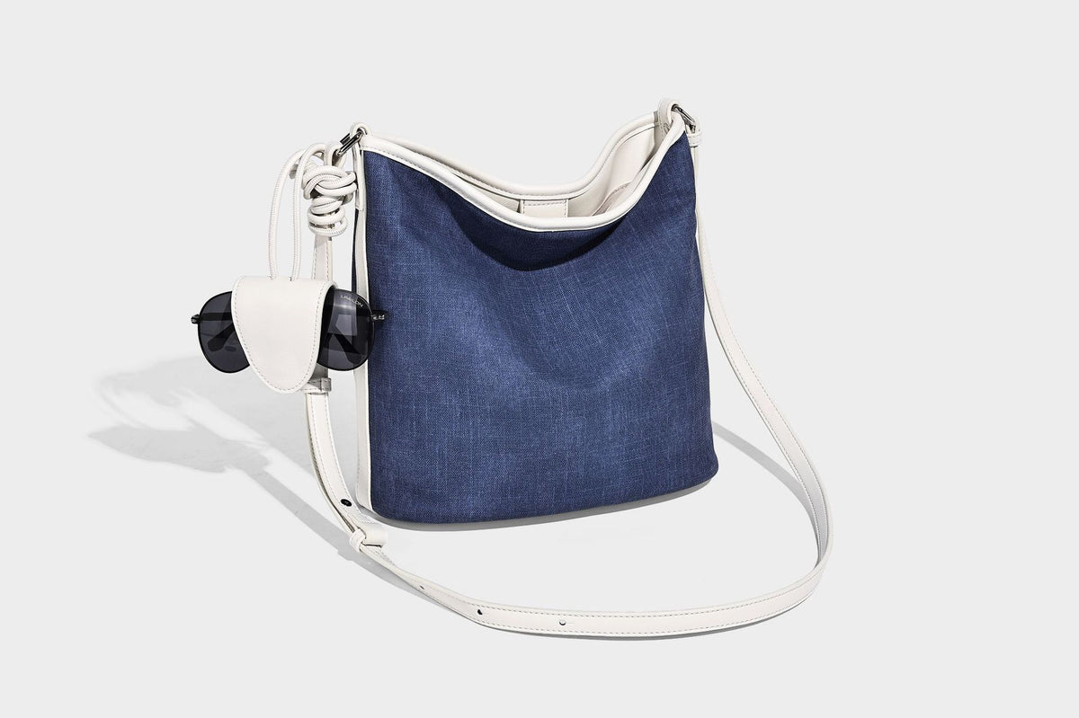 Große Bucket-Schultertasche aus Canvas in Denim-Optik mit Besatz in weißer Lederoptik, geknotetem Riemen und abnehmbarer Mini-Tasche auf der Vorderseite