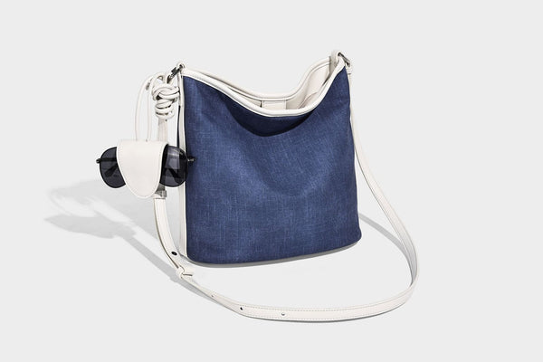 Große Bucket-Schultertasche aus Canvas in Denim-Optik mit Besatz in weißer Lederoptik, geknotetem Riemen und abnehmbarer Mini-Tasche auf der Vorderseite