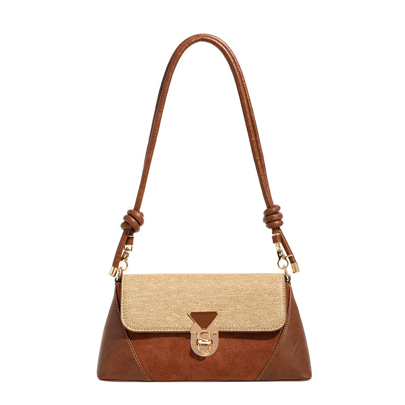 Structured trapezoid shoulder bag with pale textured flap, gold-tone triangular turn-lock closure, and long knotted cord