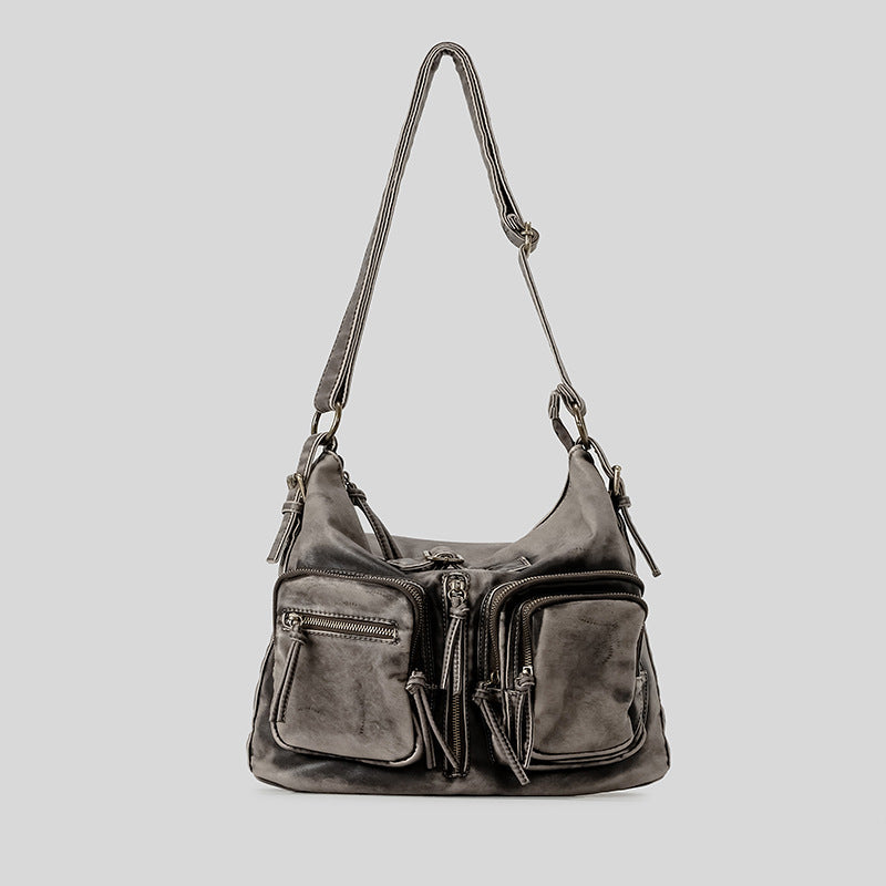 Distressed gunmetal gray hobo shoulder bag with multiple front zip pockets and adjustable crossbody strap, detail view 6