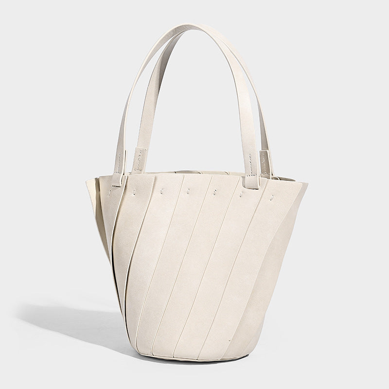Structured bucket tote bag with vertical panel exterior, dual top handles, and detachable shoulder strap in tan leather-look