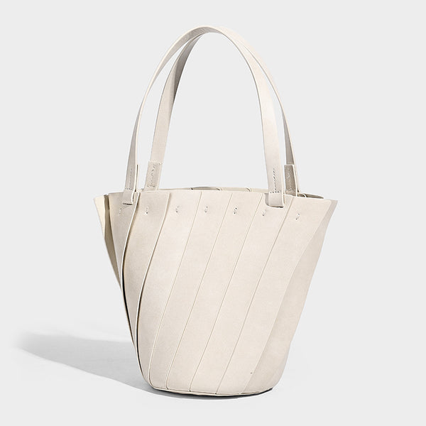 Structured bucket tote bag with vertical panel exterior, dual top handles, and detachable shoulder strap in tan leather-look