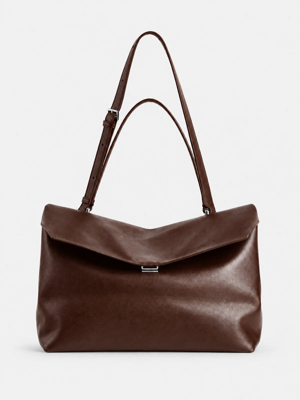 Large black slouchy leather-look shoulder bag with V-shaped envelope flap, silver-tone clasp, and adjustable strap, detail