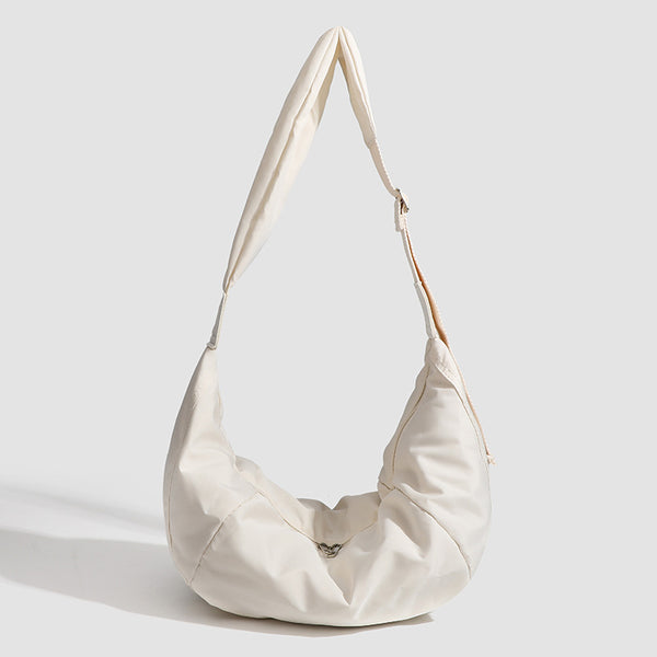 Large crescent sling shoulder bag in gathered fabric with zip closure and adjustable strap, front view