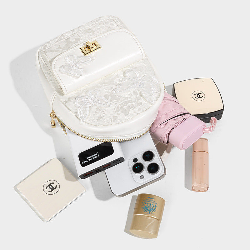 Structured mini backpack handbag with butterfly embroidery, gold-tone chain strap, and turn-lock front flap pocket, detail