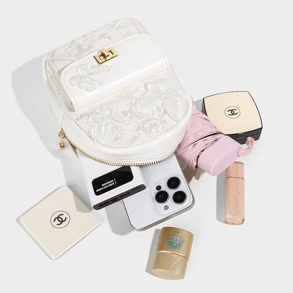 Structured mini backpack handbag with butterfly embroidery, gold-tone chain strap, and turn-lock front flap pocket, detail