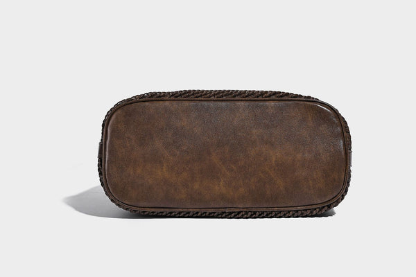 Große Schultertasche in Beutelform mit Flechtoptik, glatten Besätzen in Lederoptik, verstellbarem Riemen und hängendem Anhänger-Detail, Detailansicht
