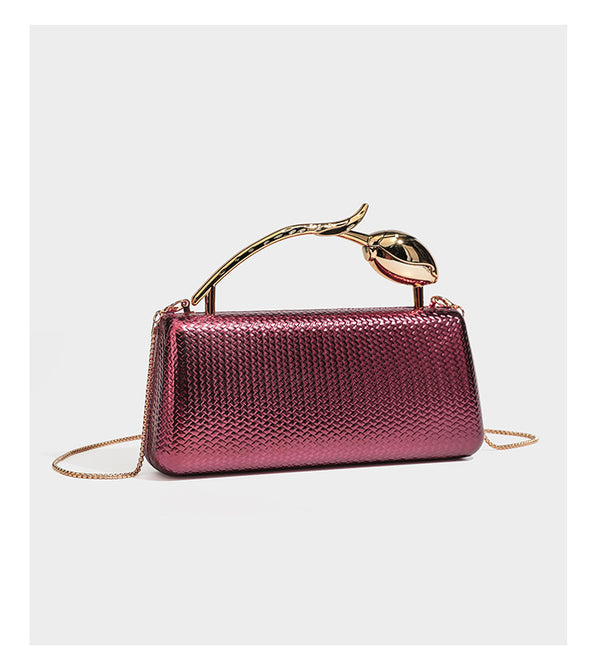 Structured rectangular metallic woven clutch bag with sculptural gold-tone leaf top handle and detachable chain strap, detail