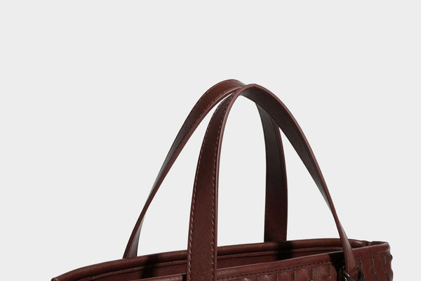Strukturierte Tote-Bag in Lederoptik mit geprägtem Flechtmuster, zwei Tragegriffen, abnehmbarem Schulterriemen und rundem Perlenanhänger
