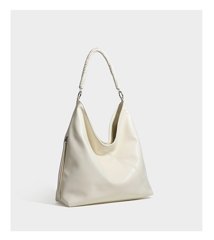 Large slouchy hobo shoulder bag with braided top handle, smooth glossy leather-look finish, and silver-tone ring hardware
