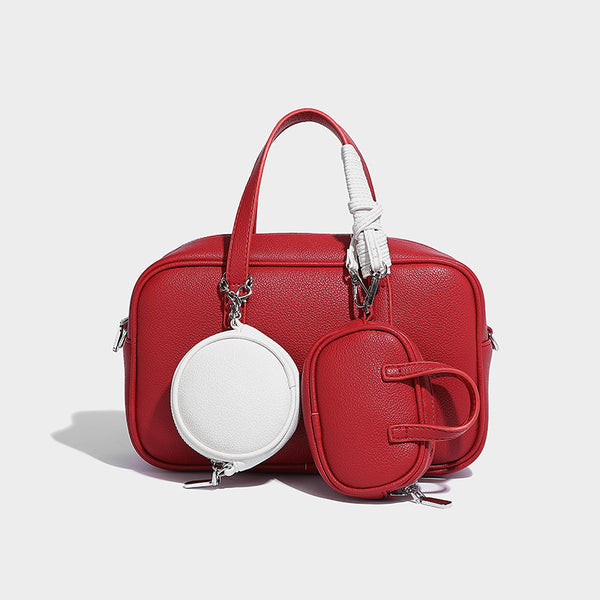 Structured pebbled leather-look Boston bowling bag in tan with blue detachable round mini pouch, dual top handles, and