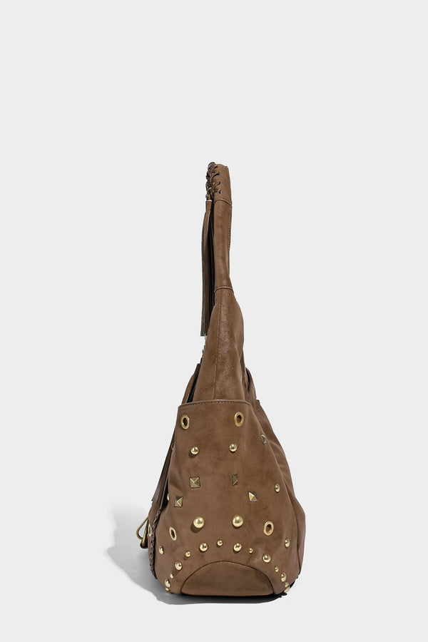 Slouchy crescent hobo bag in matte brown suede-like finish with gold-tone studs, grommets, braided top handle, tassel side