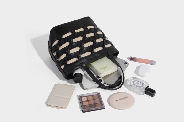 Structured woven lattice tote bag with cream lining, dual top handles, detachable crossbody strap, and silver-tone hardware