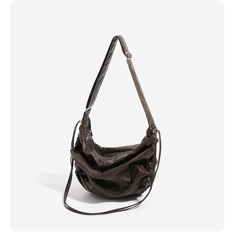Oversized slouchy hobo shoulder bag with glossy crinkled leather-look finish, drawstring gathered sides, and silver-tone