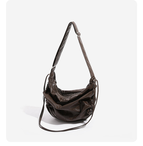 Oversized slouchy hobo shoulder bag with glossy crinkled leather-look finish, drawstring gathered sides, and silver-tone