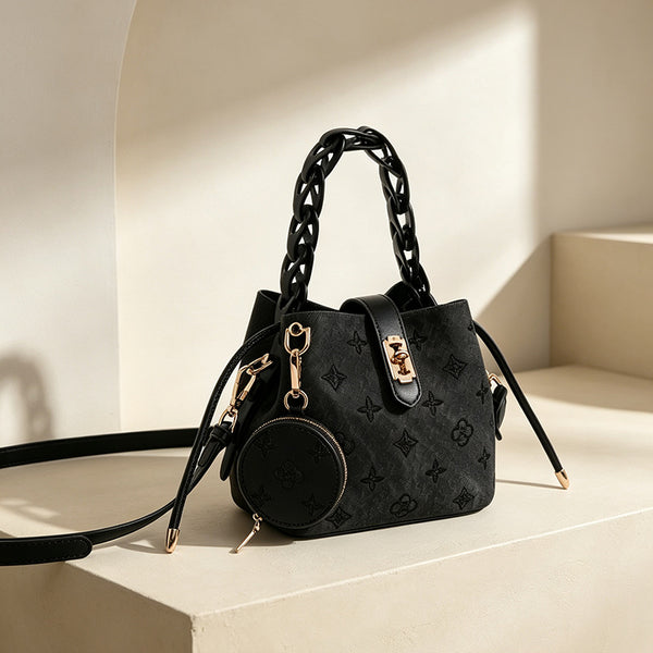 Kompakte Beuteltasche mit geprägtem Monogramm, geflochtenem Kettentragegriff, goldfarbenem Schlossverschluss und befestigtem rundem Münzfach, Detailansicht