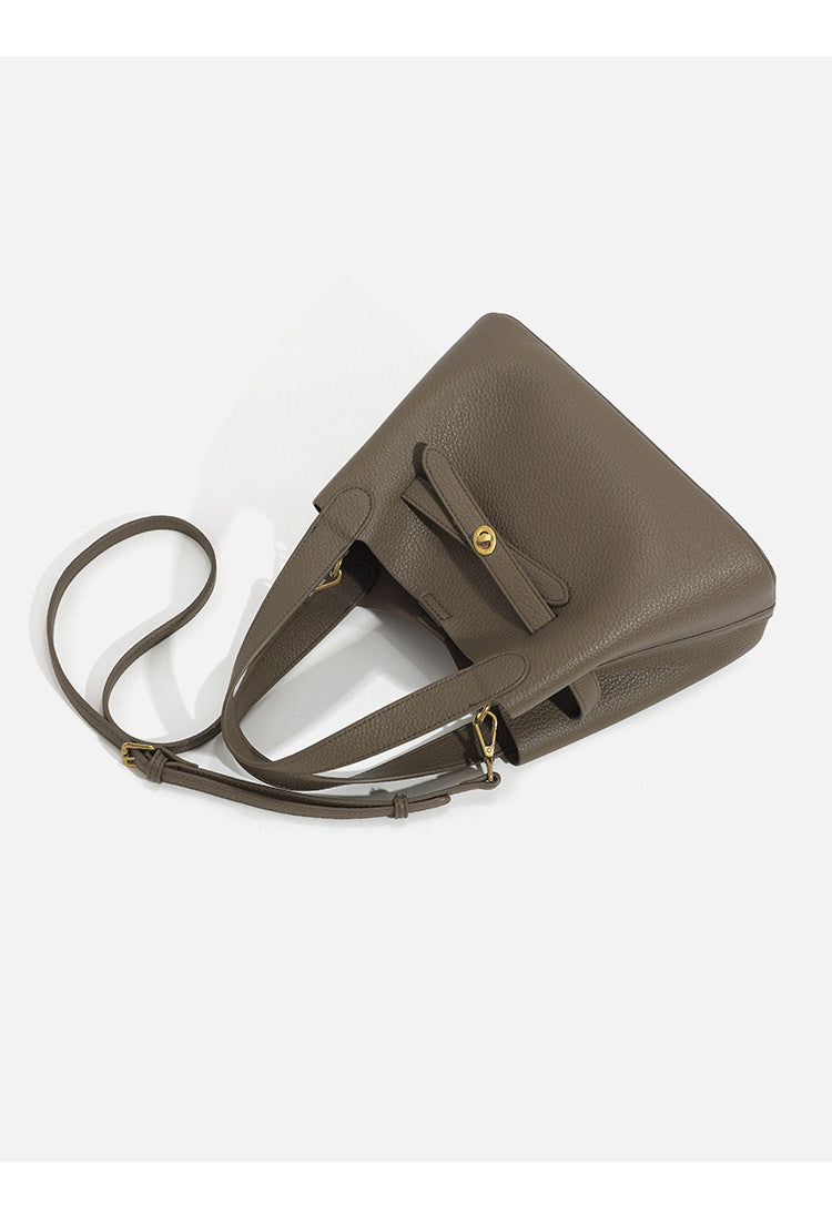 Pebbled trapezoid tote bag with gold turn-lock strap detail and matching snap pouch, detail view 12