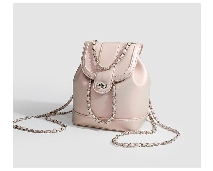 Small pearl-gloss backpack handbag with woven silver chain straps and turn-lock flap closure, detail view 9