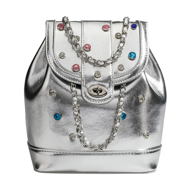 Kompakte silberfarbene Metallic-Rucksacktasche mit mehrfarbigen Kristallnieten, rundem Klappverschluss mit Drehverschluss und ineinander verflochtenem Silber