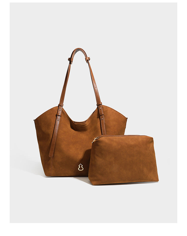 Oversized suede-finish tote shoulder bag in caramel brown with slim leather-look straps and gold-tone logo hardware, detail