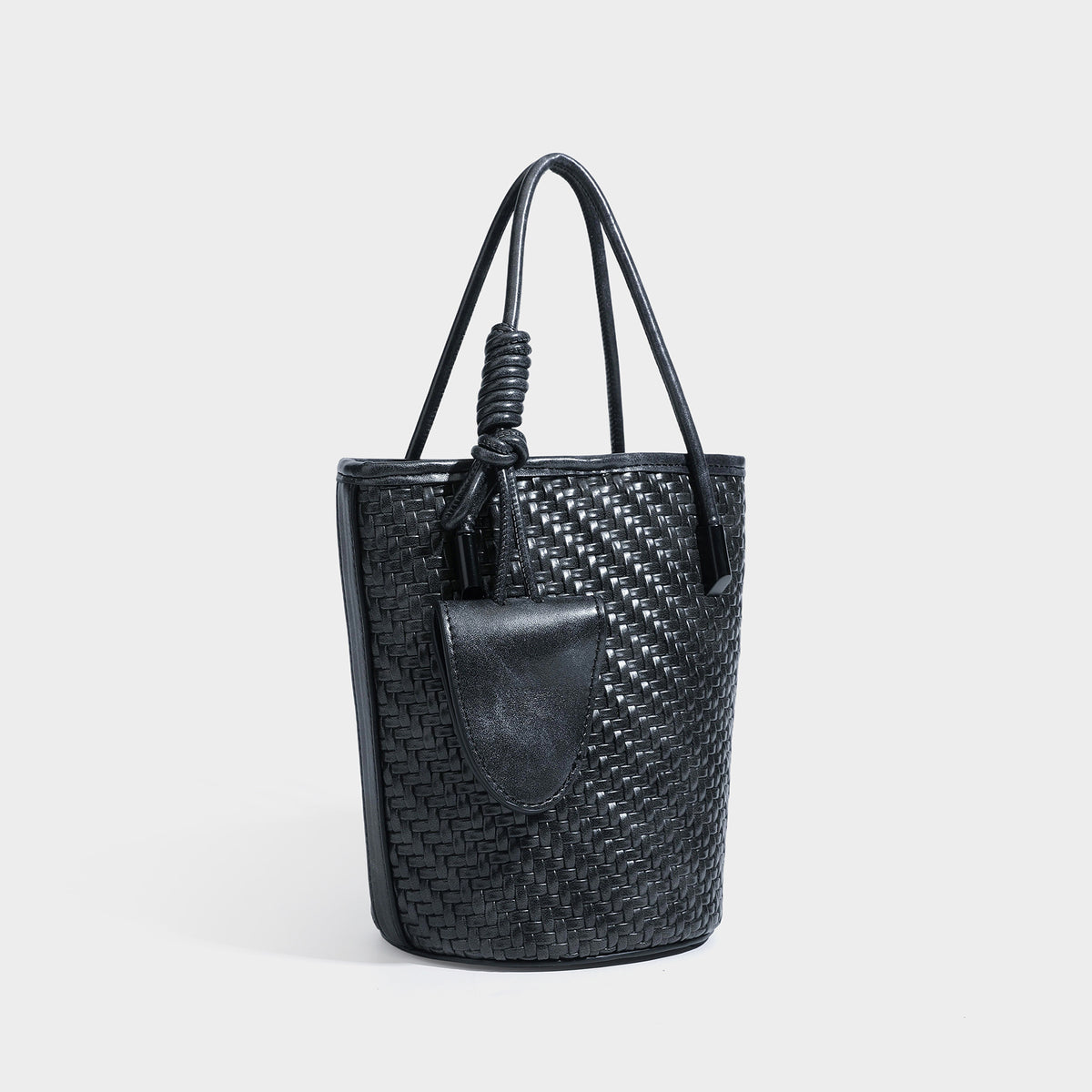 Structured woven-texture leather-look bucket bag in brown with knotted top handles, small front flap pouch, and adjustable