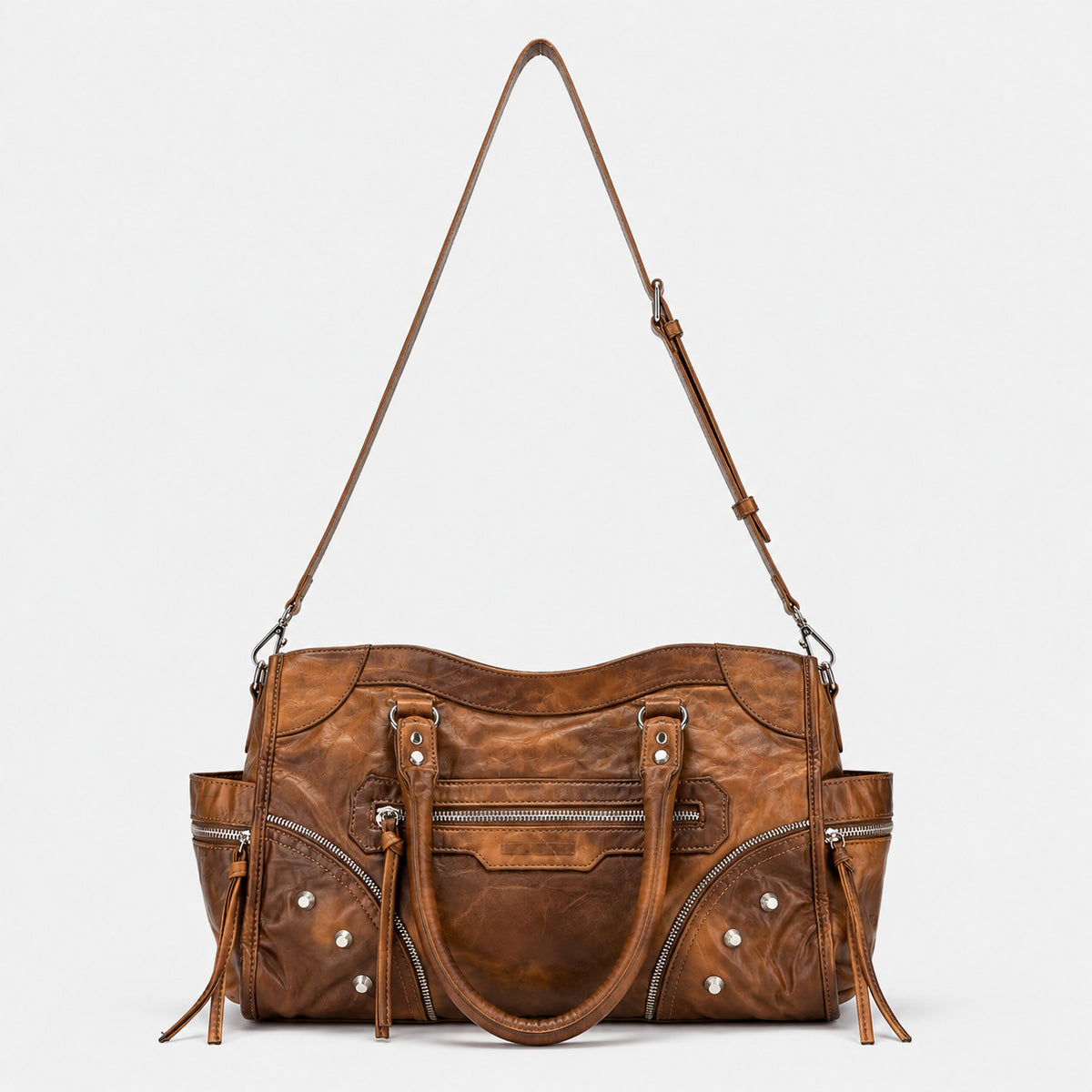Large distressed leather-look moto tote bag with silver rivets, tassel zip pulls, front zip pocket, and dual top handles
