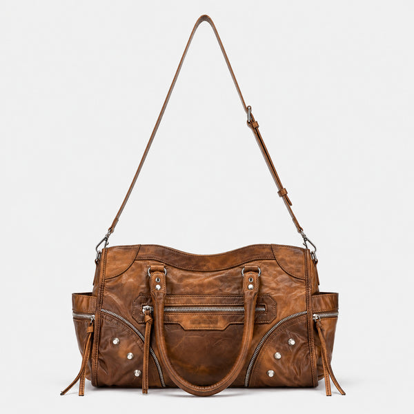 Large distressed leather-look moto tote bag with silver rivets, tassel zip pulls, front zip pocket, and dual top handles