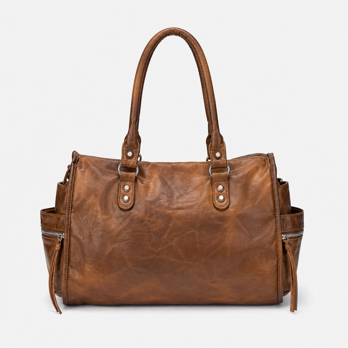 Large distressed leather-look moto tote bag with silver rivets, tassel zip pulls, front zip pocket, and dual top handles