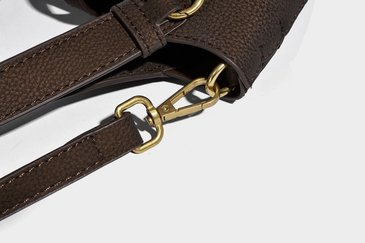 Kleine matte Beuteltasche mit genarbter Oberfläche, antikgoldfarbenen Ringbeschlägen, Perlen- und Quastenanhänger, kurzen Tragegriffen oben und