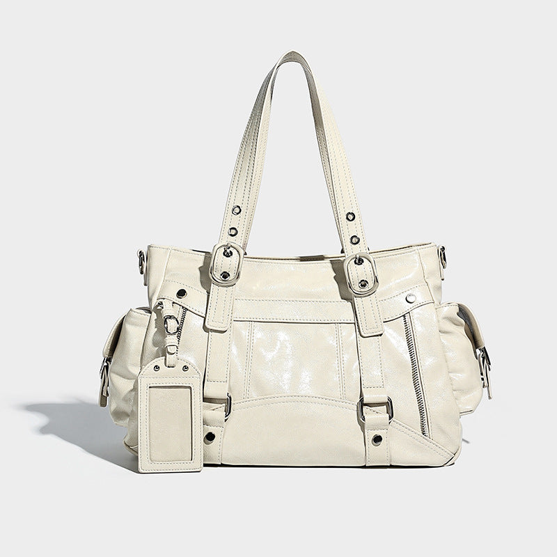 Glossy structured black tote shoulder bag with silver buckle hardware, zip pockets, dual top handles, and detachable, detail