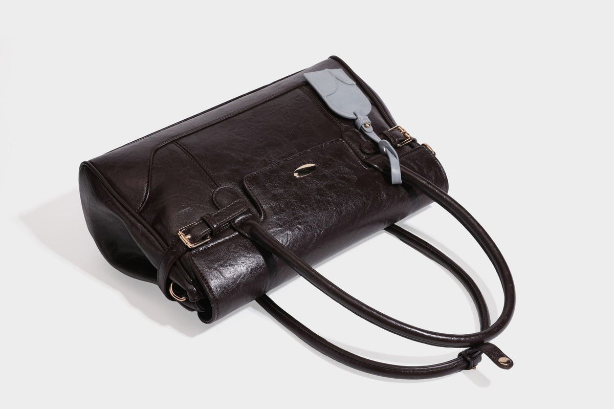 Structured glossy leather-look satchel bag with flap closure, gold-tone buckle accents, double top handles, detachable