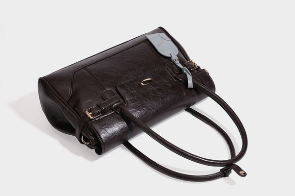 Structured glossy leather-look satchel bag with flap closure, gold-tone buckle accents, double top handles, detachable