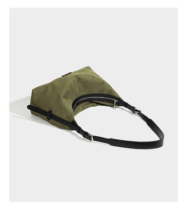 Slouchy olive green canvas hobo shoulder bag with black leather-look trim, zip-top closure, and adjustable strap, detail view