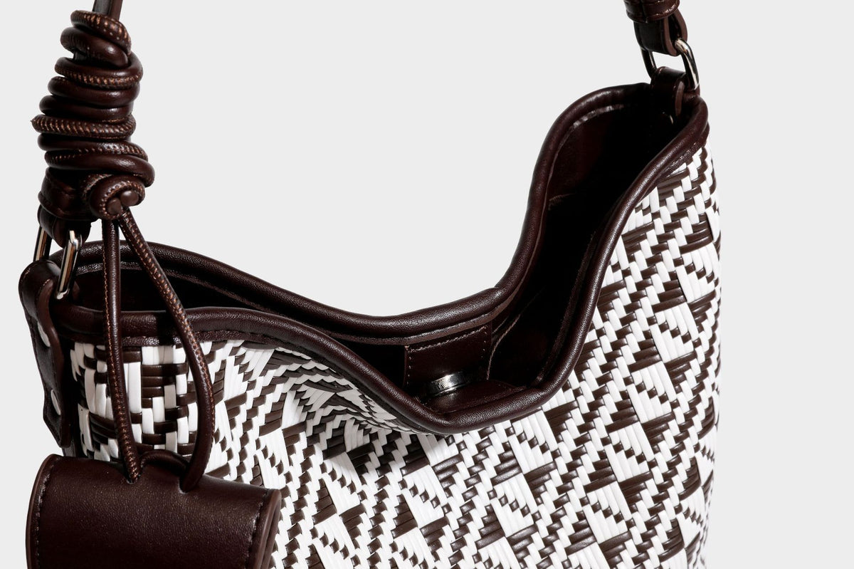 Geflochtene Schultertasche mit geometrischem Ethno-Muster, Besatz in dunkelbrauner Lederoptik, langem verstellbarem Träger und kleinem hängendem Reißverschluss