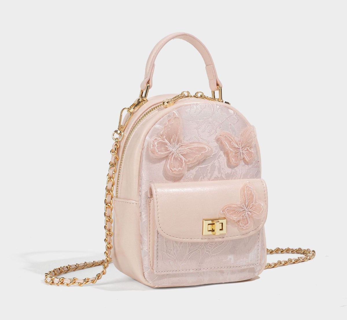 Structured mini backpack handbag with butterfly embroidery, gold-tone chain strap, and turn-lock front flap pocket, detail