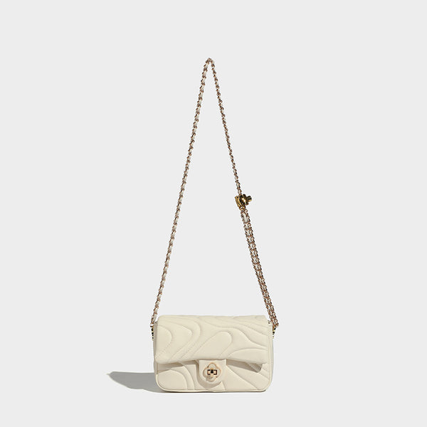 Compact cream quilted flap crossbody bag with wave stitching, gold-tone chain strap, and four-petal turn-lock clasp, front