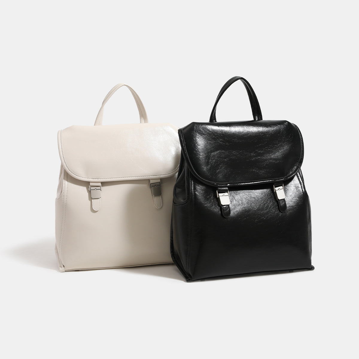Structured glossy leather-look flap backpack with twin buckle closures and top grab handle, detail view 2