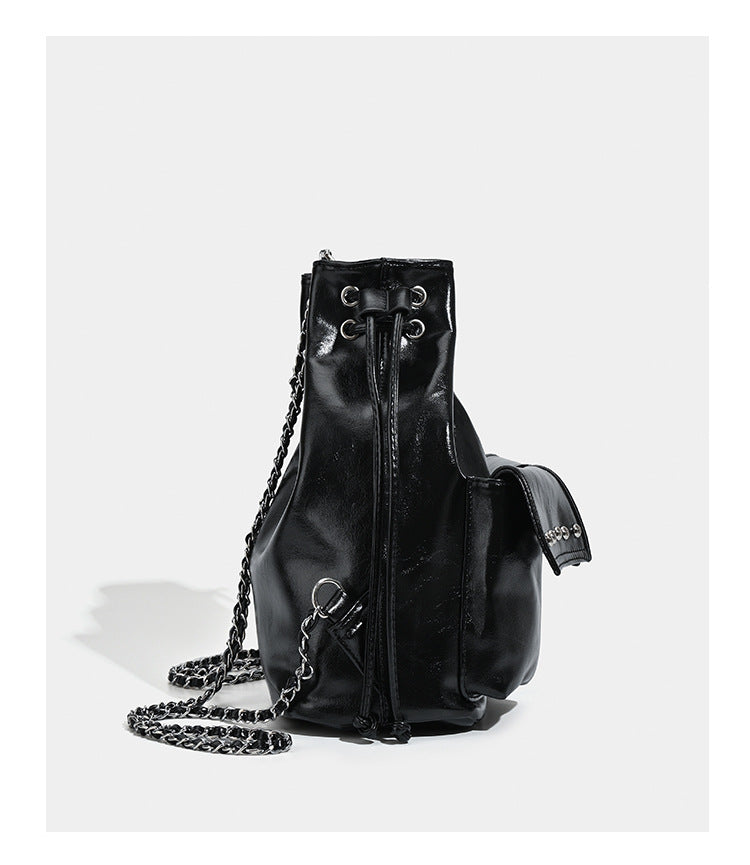 Glossy leather-look drawstring bucket bag with silver dome studs and chain shoulder strap, detail view 12