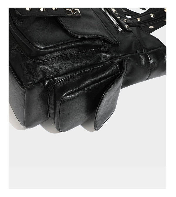 Black leather-look tote bag with silver pyramid studs on handles and front panel, multiple flap and zip exterior pockets