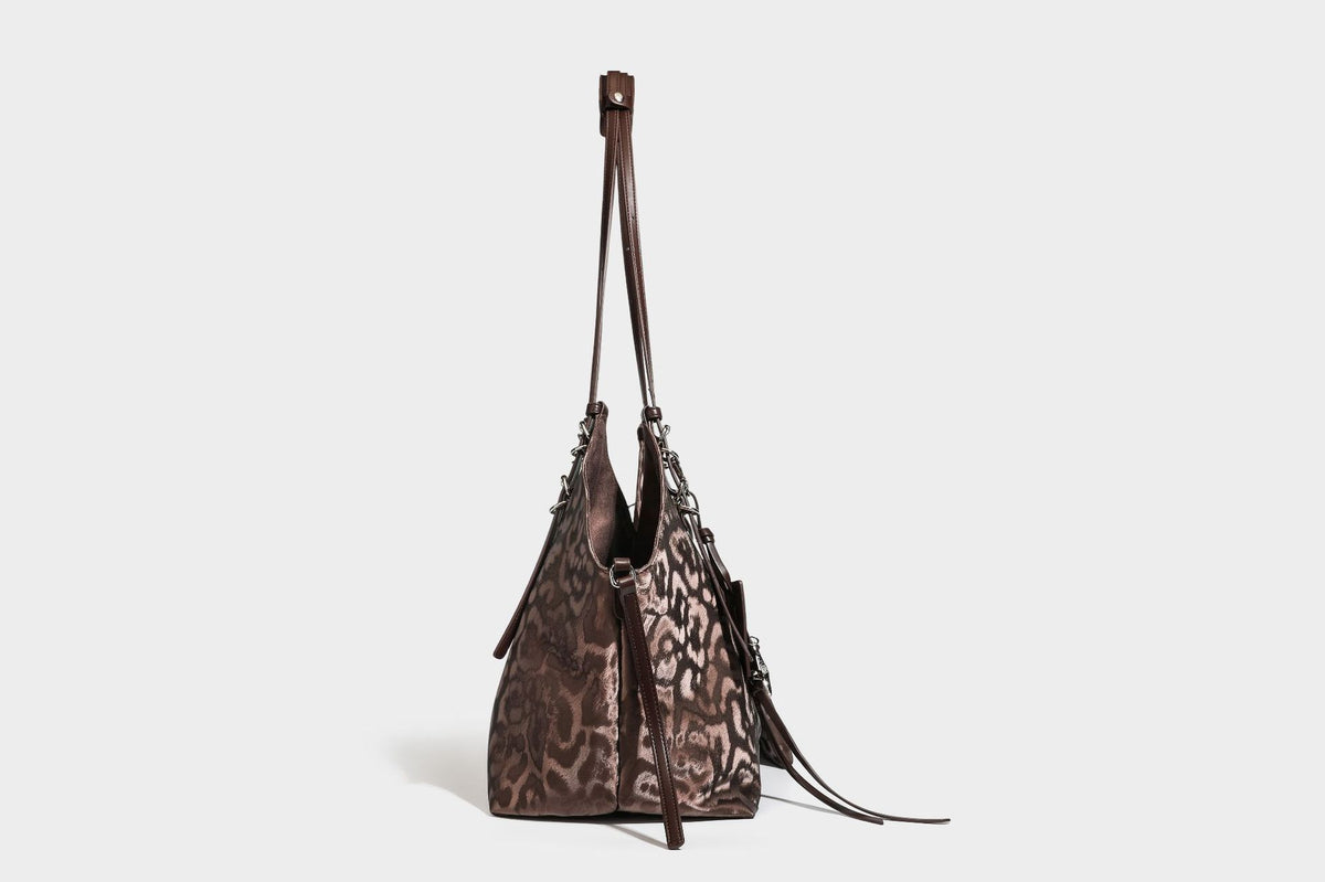 Große, glänzende Hobo-Schultertasche mit Leopardenprint, abnehmbarem Reißverschlusstäschchen und silberfarbenem Seestern-Anhänger, Detailansicht
