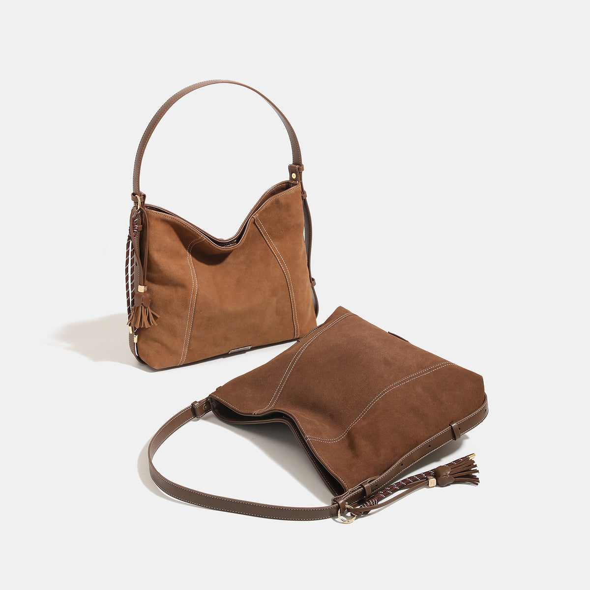 Slouchy suede-finish hobo shoulder bag in warm mocha brown with contrast stitching, braided tassel side accent, and, detail